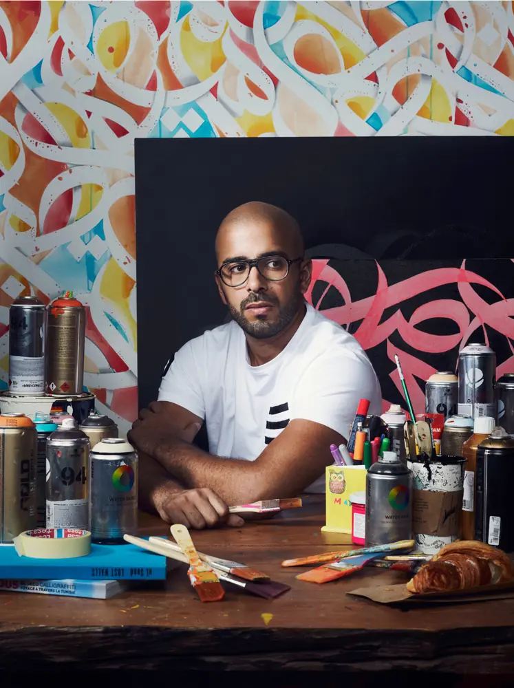 Environmental portrait of an artist holding a painted work