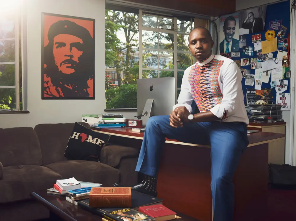 Environmental portrait of a man seated in a layered interior