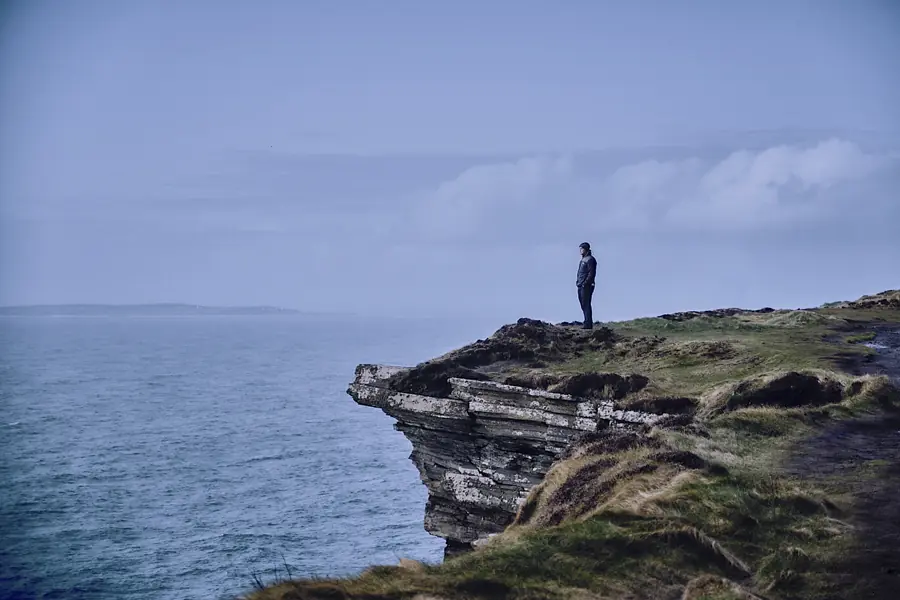 Figure standing on an Atlantic cliff