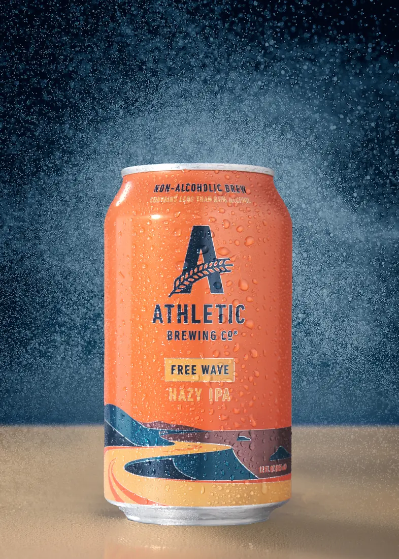 Athletic Brewing Free Wave can with an orange and blue spray backdrop