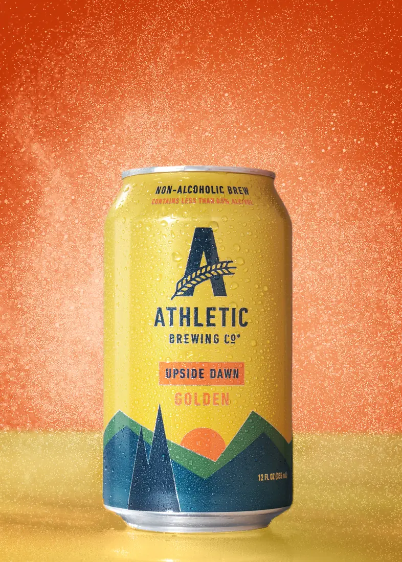 Athletic Brewing Upside Dawn can with an orange spray backdrop