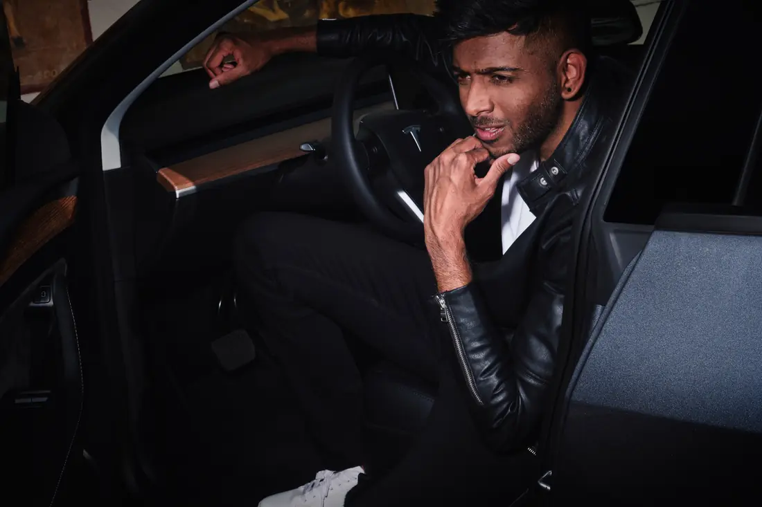 Fashion portrait of a man seated in a car at night