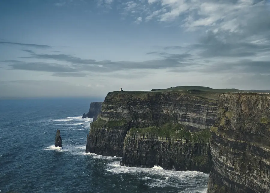 Sea cliffs and a solitary rock stack under shifting coastal light