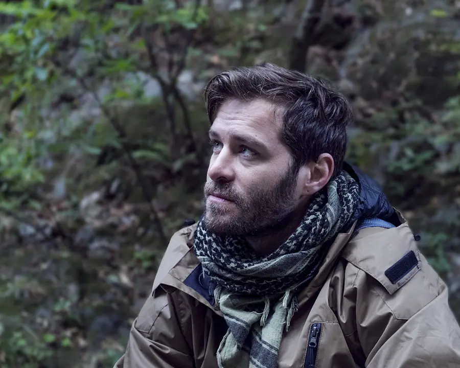 Cinematic portrait of a bearded man in a green forest