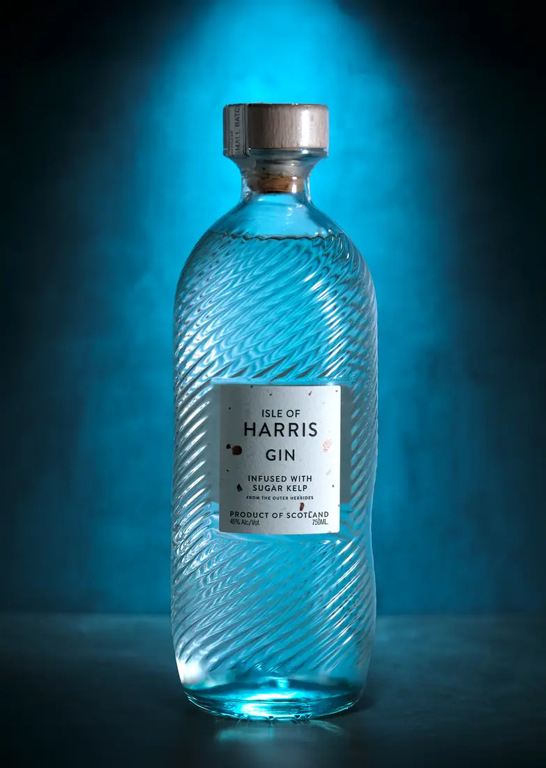 Blue Harris Gin bottle photographed against a glowing blue background