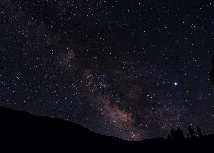 Milky Way rising above a dark mountain ridge