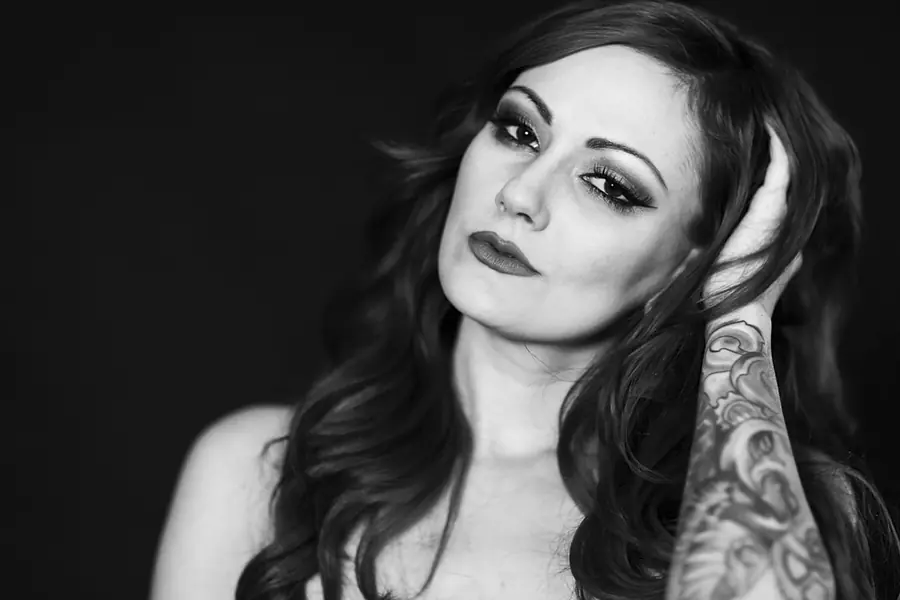 Black-and-white portrait of a tattooed woman