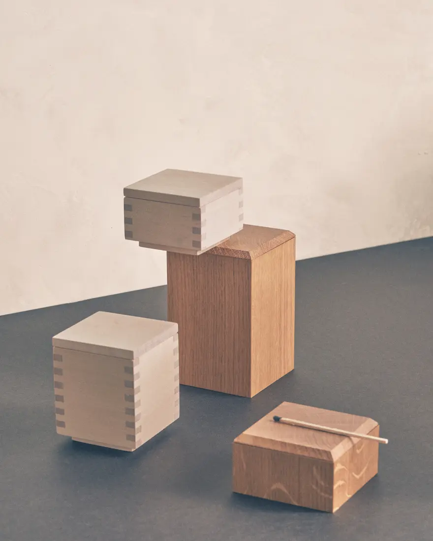 Handcrafted wooden boxes and small reflective objects arranged in a geometric still life