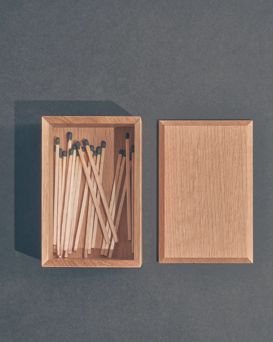 Overhead still life of wooden matches arranged inside a handcrafted wood box