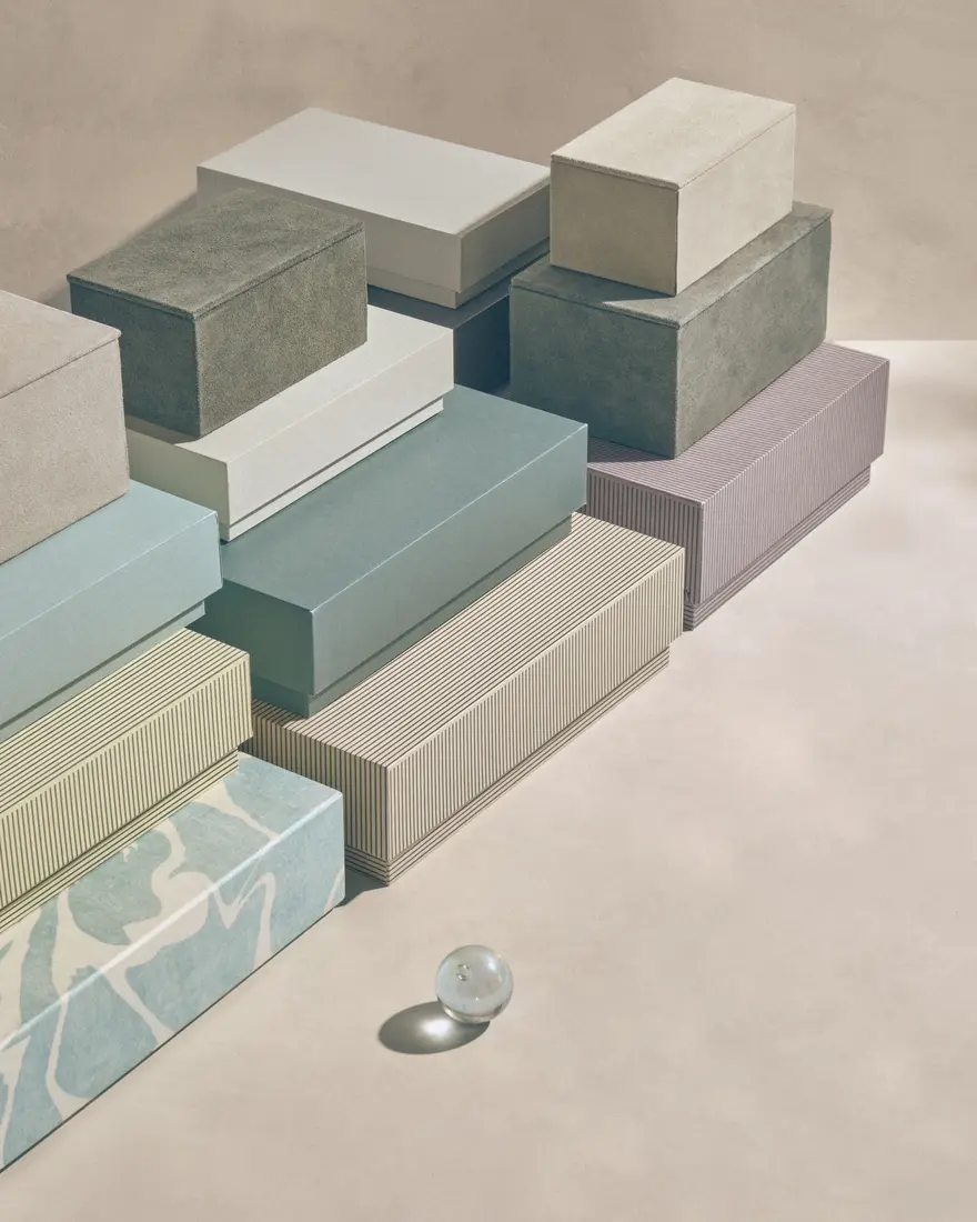 Sculptural stack of muted pastel boxes with reflective glass spheres